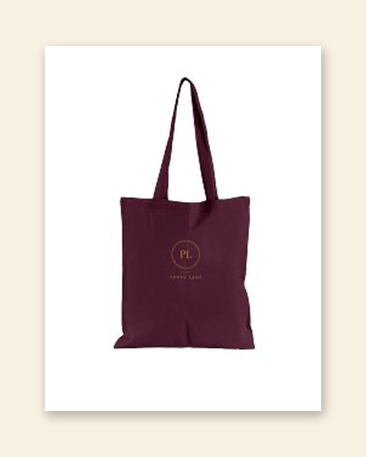 Shop mockup of the Monogram Tote in burgundy canvas: the PL monogram in an old gold ring with the words Poppy Lane beneath, on a white card