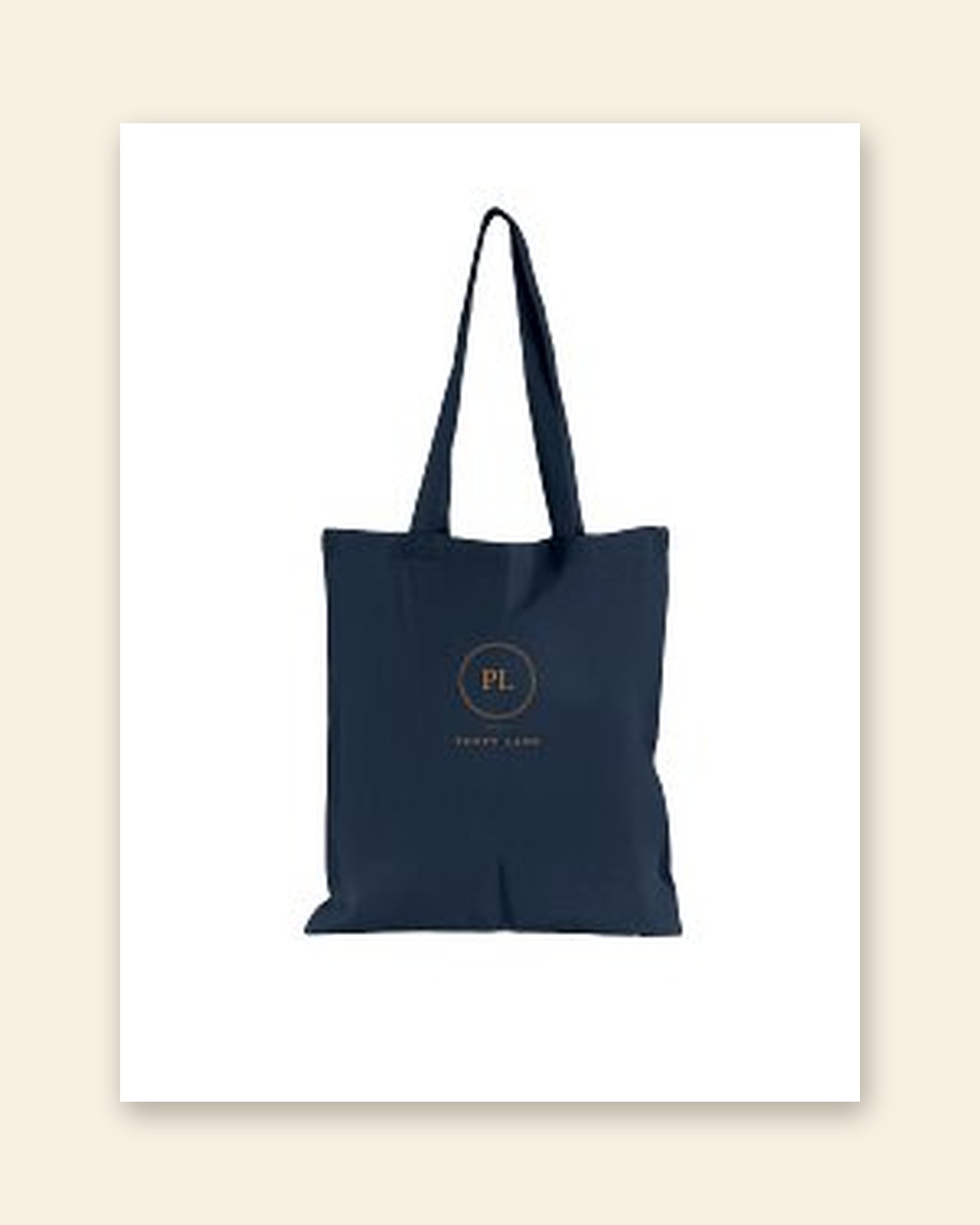 Shop mockup of the Monogram Tote in French navy canvas: the PL monogram in an old gold ring with the words Poppy Lane beneath, on a white card